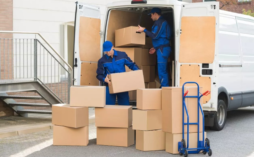 Skilled movers unloading packed boxes from a moving truck during a safe and efficient long-distance moving process.