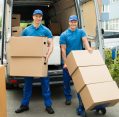 Professional movers loading cardboard boxes into a moving van for a smooth and reliable long-distance moving service.